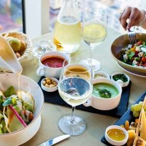 vegetable salad on white ceramic bowl beside clear wine glass