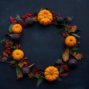 round Halloween-themed wreath on blue surface