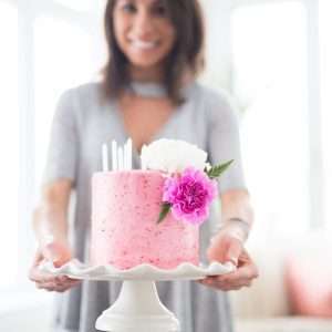 woman holding one layer of cake with stand