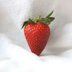 red strawberry on white textile