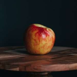 red apple fruit on brown wooden table