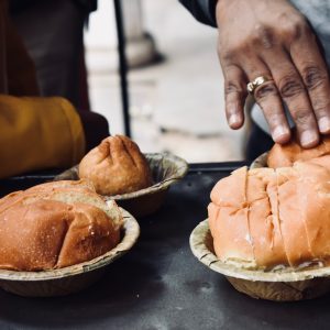 person holding bread on bowl at daytime