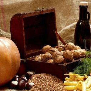 a wooden box filled with nuts next to a bottle of wine