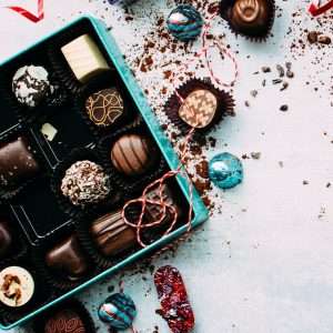 chocolates with box on white surface