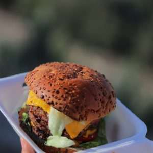 a person holding a tray with a hamburger and french fries