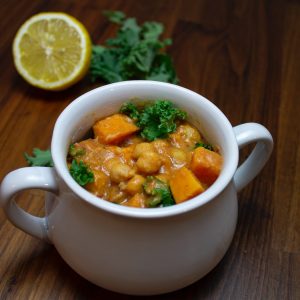 a bowl of food on a table next to a lemon