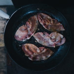 bacon on top of black cast-iron skillet