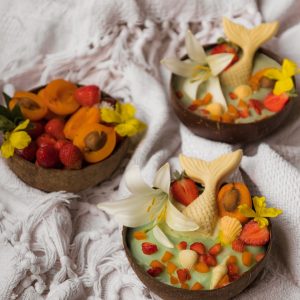 three small bowls filled with fruit and flowers