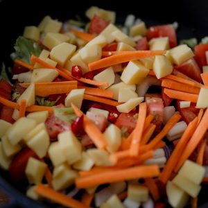 sliced carrots and green vegetable in black ceramic bowl