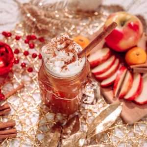 juice with toppings near sliced apple fruits and cinnamon sticks