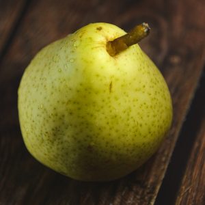 a green apple sitting on top of a wooden table