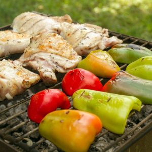 a bbq with chicken, peppers, and peppers on it