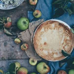 baked pie beside green apples