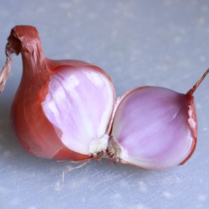 2 red onions on white table