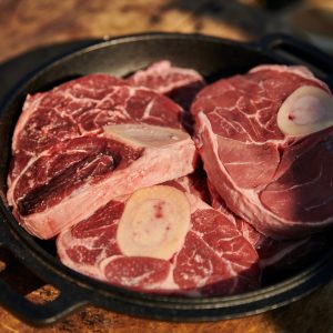 raw meat in a frying pan on a wooden table