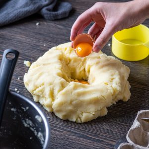 person holding orange plastic lid with white cream