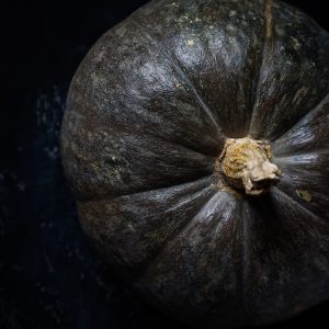 green and yellow pumpkin on black table