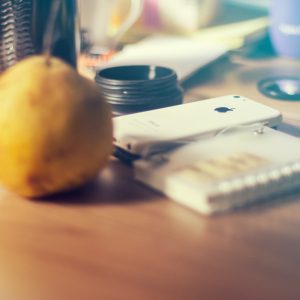 a table with a lemon, a cell phone, and other items