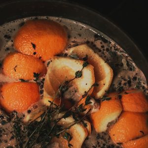 a pot filled with oranges and herbs