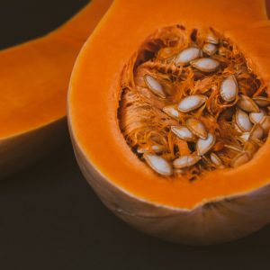 a close up of a pumpkin with seeds inside of it