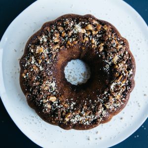 peanut sprinkled doughnut placed on round white ceramic saucer