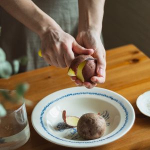 person holding sliced fruit on white ceramic plate