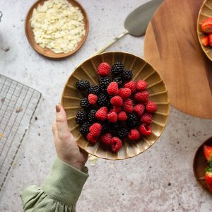 person holding bowl of strawberries