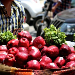 a basket of apples and lettuce on a table