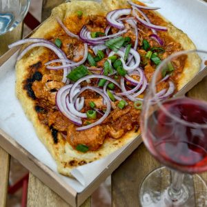 pizza with green leaf vegetable on white ceramic plate