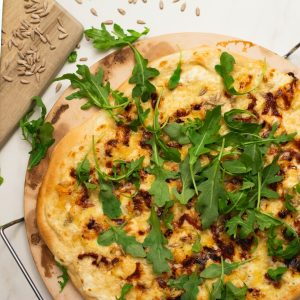 a pizza sitting on top of a wooden cutting board