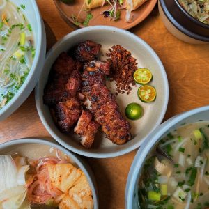 a wooden table topped with bowls of food