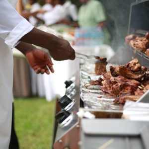 person in white shirt grilling meat
