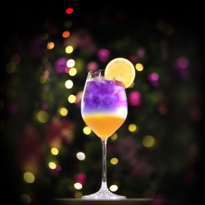 yellow and purple drink in wine glass