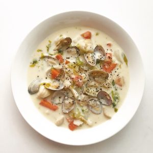 clam and vegetable soup in white ceramic bowl