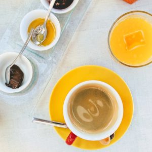 white ceramic mug with coffee on yellow saucer