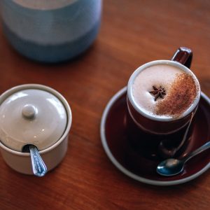 coffee mug on saucer beside canister