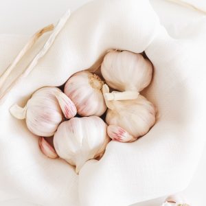 five garlic on white textile