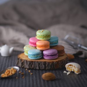 assorted-color macaroons on wood slab
