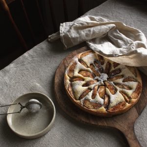a pastry on a wooden board next to a bowl