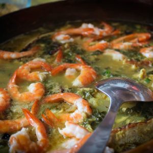 a pot of soup with shrimp and broccoli