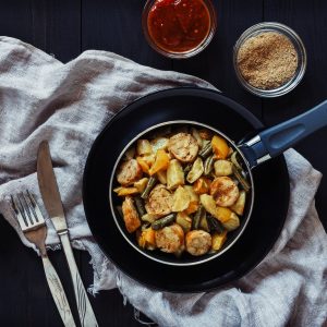 a pan filled with food next to a fork and knife