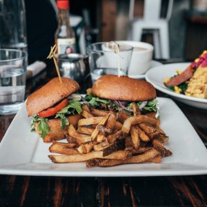 selective focus photo of burgers and fries served on plate