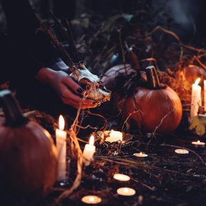 person decorating pumpkin and candles