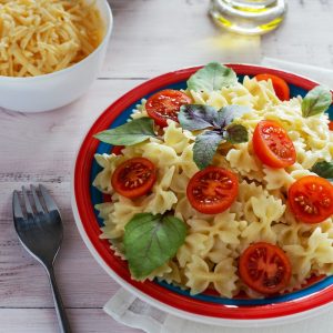 a plate of pasta with tomatoes and basil