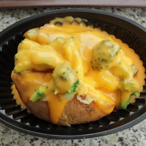 a baked potato covered in cheese and broccoli