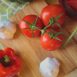 three tomatoes beside garlic