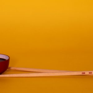 brown wooden chopsticks on red and black ceramic bowl