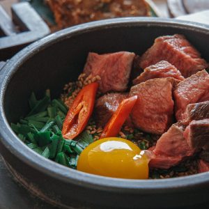 a bowl filled with meat and vegetables on top of a table