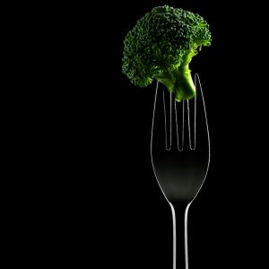 a fork with a piece of broccoli sticking out of it