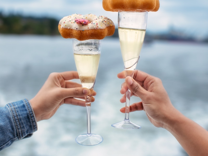 A couple of people holding wine glasses filled with food
